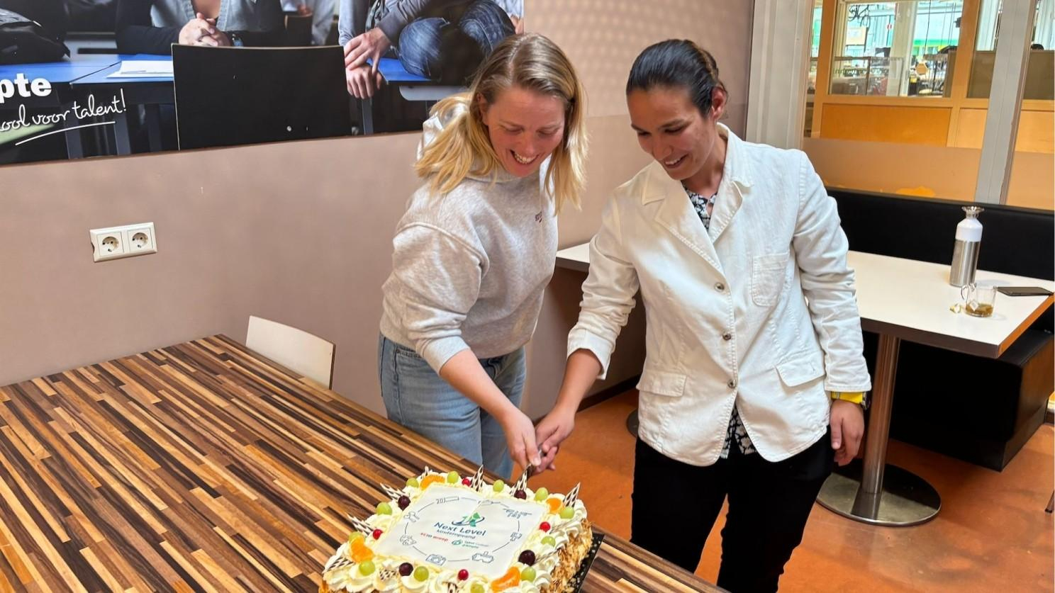 De taart wordt aangesneden door Mirjam Grunstra (co�rdinator Techlab) en G�lsah Direk�i (SCIO groep). 